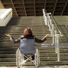 A person in a wheelchair at the foot of steps